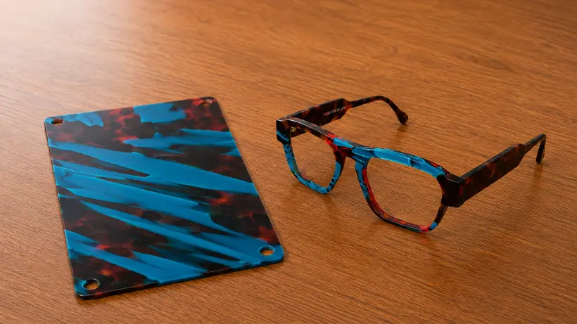 Monture de lunettes et plaque d'acétate recyclé Nextone aux reflets multicolores, illustrant la composition unique du coloris éco-responsable