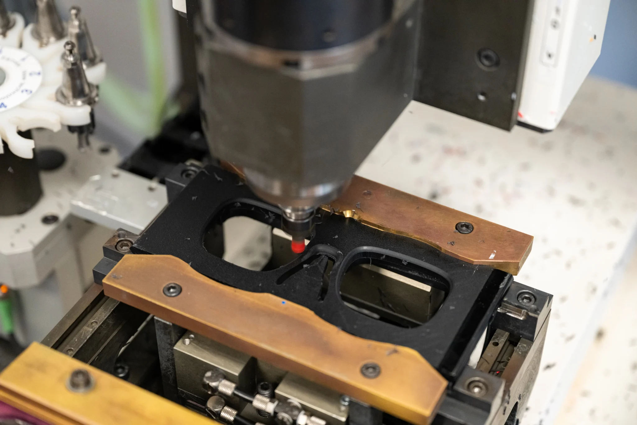 Une face de monture noire découpée par la fraise d'un centre d'usinage, à l'atelier Nextone de Montrichard